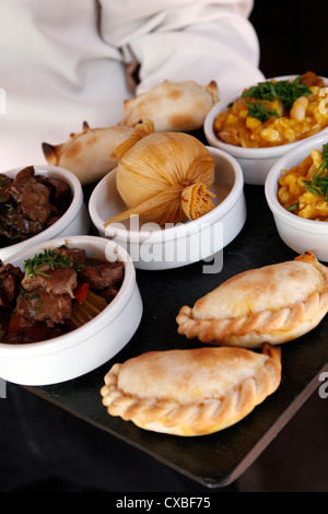 A tray with traditional food from the northwest, including empanadas, locro and humitas, Purmamarca, Jujuy Province, Argentina. Stock Photo