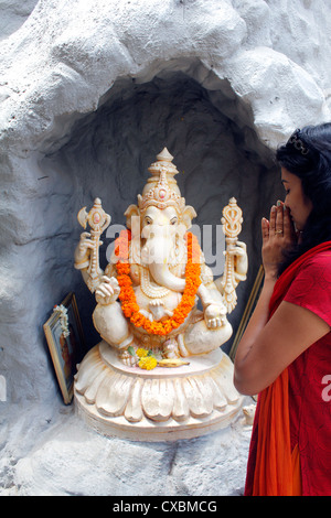 Indian woman praying to Lord Ganesha Stock Photo
