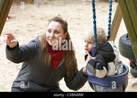 Berlin, busy educator with a boy sitting in a swing Stock Photo