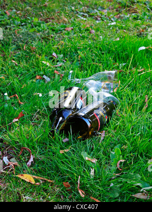 Two discarded bottles and a pair of wine glasses at riverside, Norwich, Norfolk, England, United kingdom. Stock Photo
