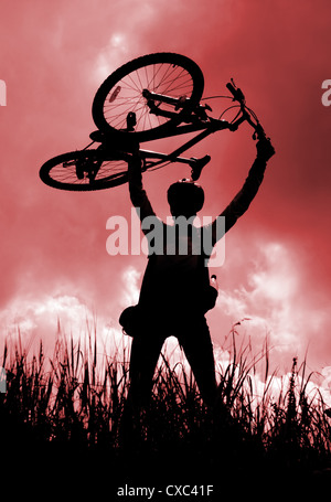 Silhouette of a biker holding his bicycle, red tint Stock Photo