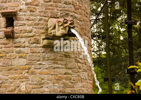 Stone tower with water feature and dove coot and water spouting gargoyles, Westonbury Mill water gardens, Pembridge, Herefordshi Stock Photo