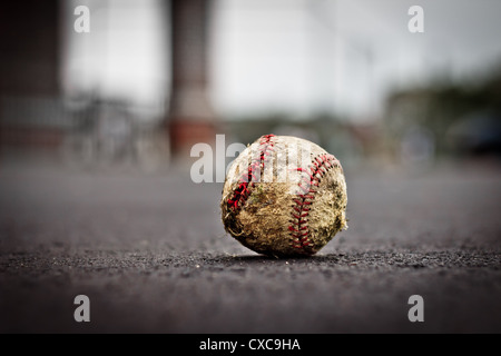 Grungy well worn old baseball on ground with very shallow depth of field Stock Photo