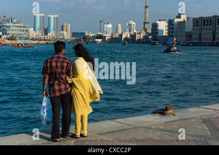 A young couple of Indians enjoys the view of Dubai Creek on December 31, 2004 in Dubai, UAE. Stock Photo