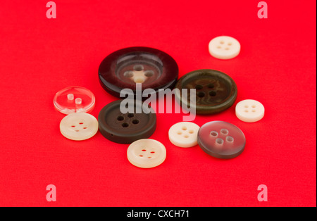 Assortment of different buttons on red background. Stock Photo