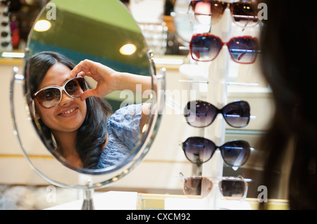 Mixed race woman shopping for sunglasses Stock Photo