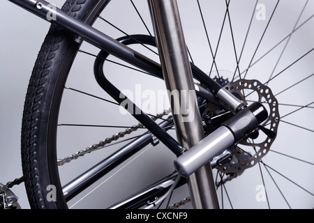 Bicycle attached to a metal pole with a U lock Stock Photo