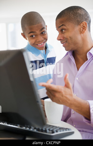 Mixed race man and son using computer together Stock Photo