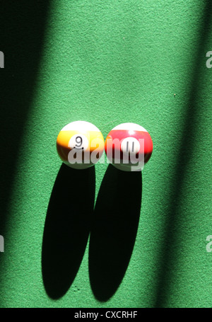 It's a photo of a details of a snooker with some strong ray of sun and shadows. We can see the snooker black ball 8, 11, 9 Stock Photo