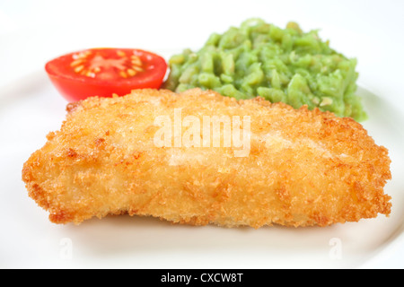 A small meal of oven baked breaded fish with mushy peas and half a tomato, 220 calories or 921 kilojoules. Stock Photo