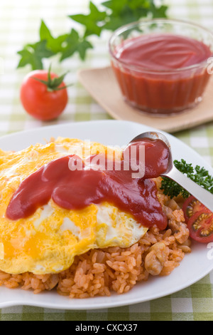 Putting Tomato Ketchup on Omurice Stock Photo