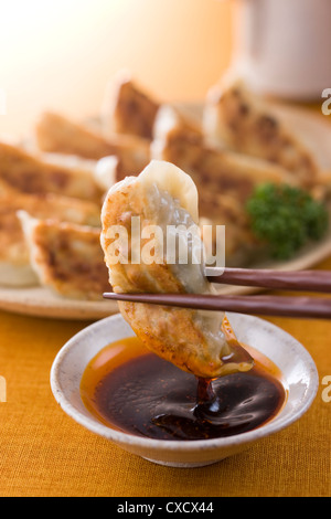 Dipping Pot Sticker into Chili Oil Stock Photo