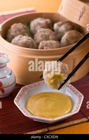 Putting Chinese Hot Mustard on Shaomai Stock Photo