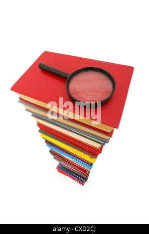 Magnifying glass over the stack of books Stock Photo