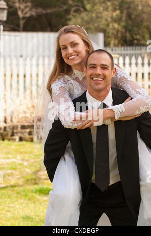 Caucasian groom carrying bride Stock Photo