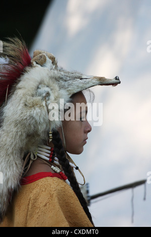 A Native American Indian boy wearing traditional leather dress and a coyote skin fur hat headress Stock Photo