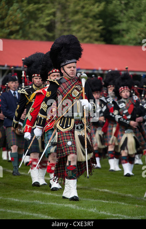 Village of Braemar, Scotland. A Drum Major marching with the massed pipe bands at the Royal Braemar Gathering games. Stock Photo