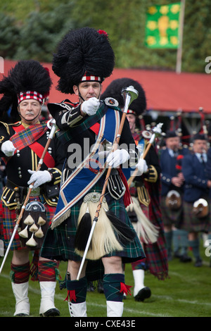 Village of Braemar, Scotland. Drum Major Roland Stuart leads the massed pipe bands at the Royal Braemar Gathering games. Stock Photo