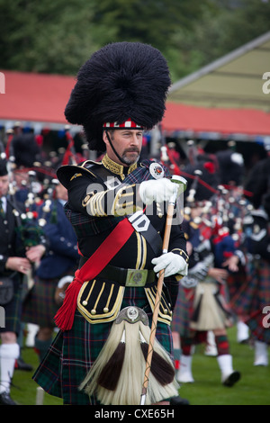 Village of Braemar, Scotland. A Drum Major marching with the massed pipe bands at the Royal Braemar Gathering games. Stock Photo