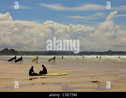 Surfers with boards on Perranporth beach, Cornwall, England Stock Photo