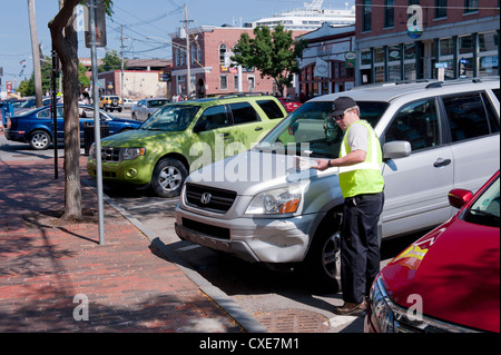 Traffic warden issues a parking ticket in downtown Portland, Maine, USA. Stock Photo