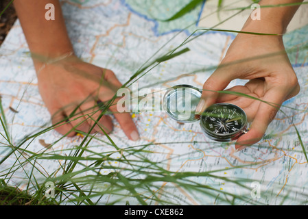 Woman using compass and map outdoors, cropped Stock Photo