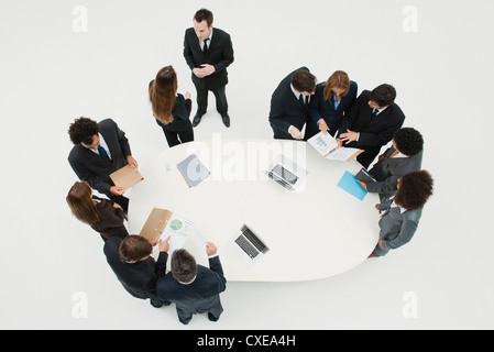 Business associates working together in groups around table Stock Photo