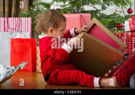 Baby girl opening Christmas present Stock Photo