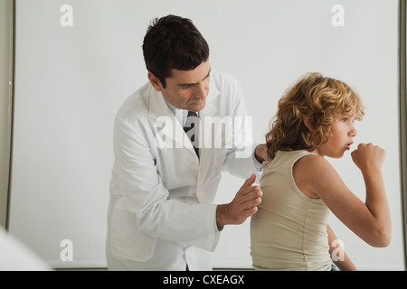 Doctor checking young patient's cough Stock Photo