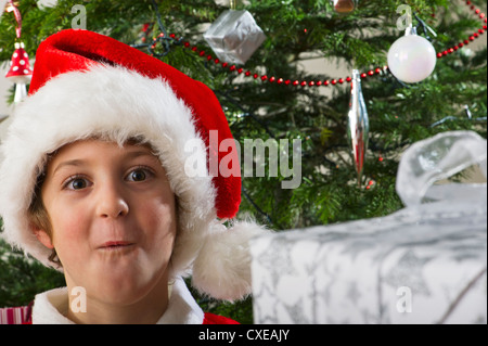 Boy in Santa hat making surprised face, portrait Stock Photo