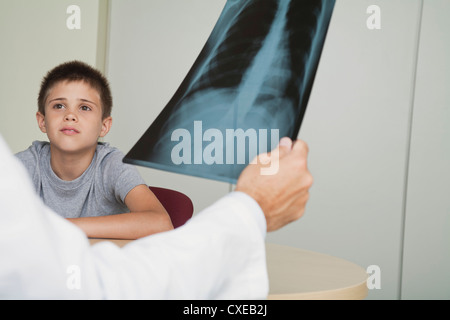 Doctor sitting across from boy looking at x-ray Stock Photo
