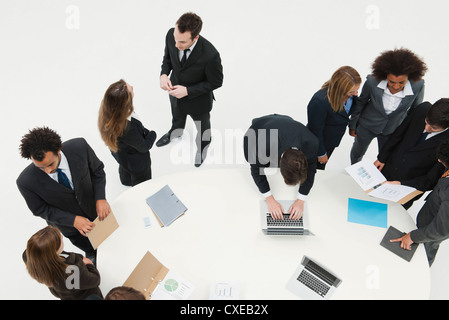 Business associates working together in small groups around table Stock Photo