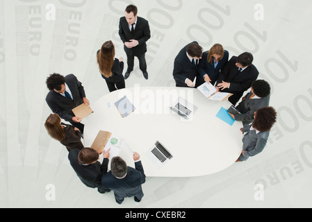 Business associates in meeting, standing on superimposed image of one-hundred Euro banknotes Stock Photo
