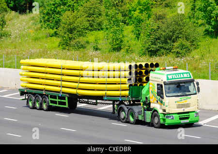 Haulage Contractor lorry and trailer transporting a load of yellow gas pipes Stock Photo