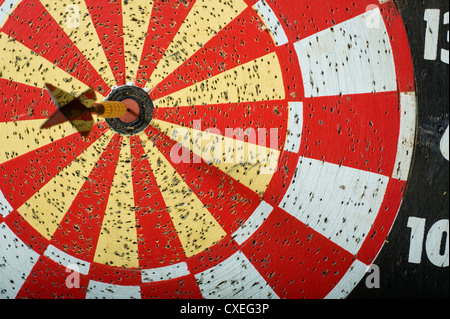 A dart in the bullseye on a dartboard with copy space Stock Photo