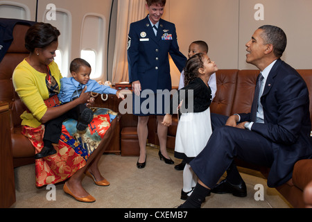 US President Barack Obama and First Lady Michelle Obama greet the family of Senior Master Sergeant Roland Paramore (not pictured) September 19, 2011 aboard Air Force One prior to departure en route to New York. Stock Photo