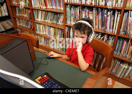 Boy using a computer at a public library Stock Photo