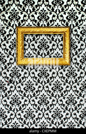 Gold frame on a black and white wallpaper Stock Photo