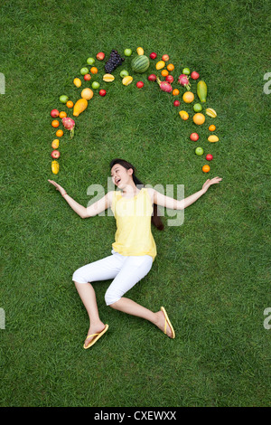 Young woman with fresh fruits on meadow Stock Photo