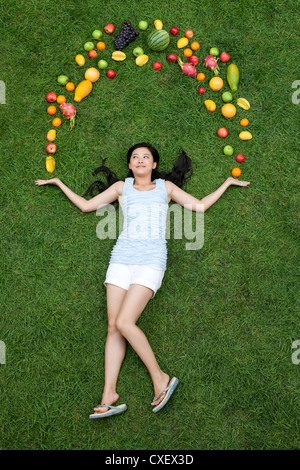 Young woman with fresh fruits on meadow Stock Photo