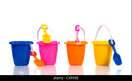 Row of brightly colored beach buckets and shovels on a white background Stock Photo