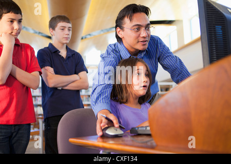 Teacher showing student how to use computer Stock Photo