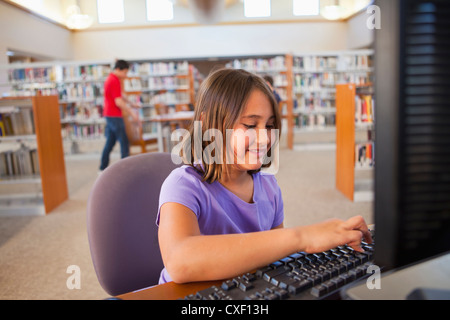 Girl using computer in library Stock Photo