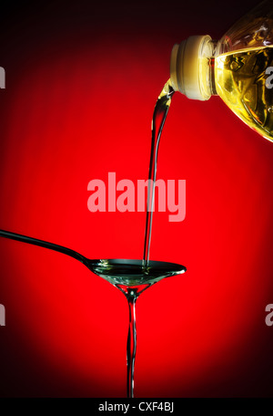 pouring oil on spoon Stock Photo