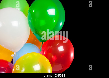 Bouquet of various colored balloons on a black background with copy space Stock Photo