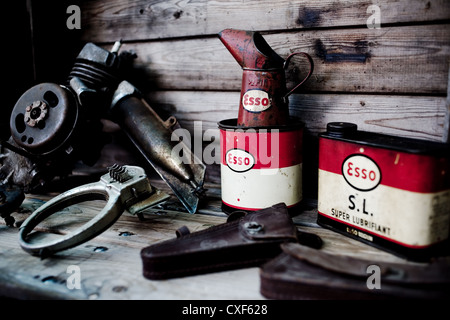 Still life image of old oil cans and a moped engine. Stock Photo