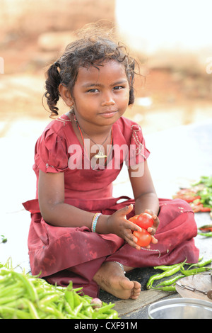 Little Indian girl Karuna playing with a pot and vegetables Andhra Pradesh South India Stock Photo