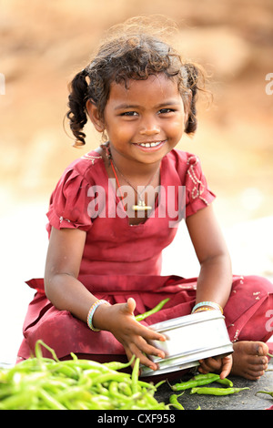 Little Indian girl Karuna playing with a pot and vegetables Andhra Pradesh South India Stock Photo