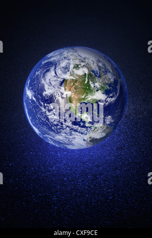 A Glowing earth on asphalt road. Earth image provided by NASA.