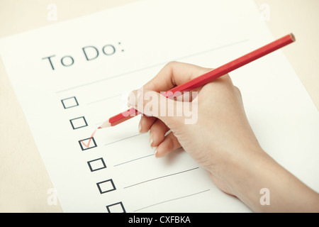 Human hand writing on a checklist document Stock Photo